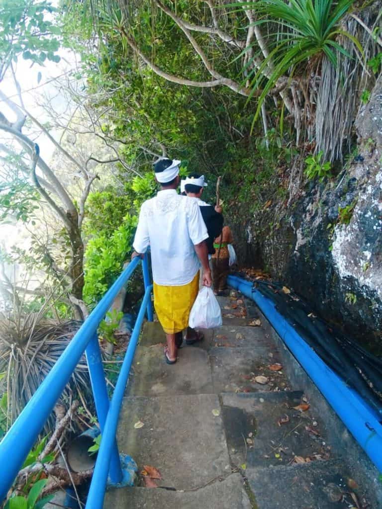 Locals walking down steps to Peguyangan Waterfall 
