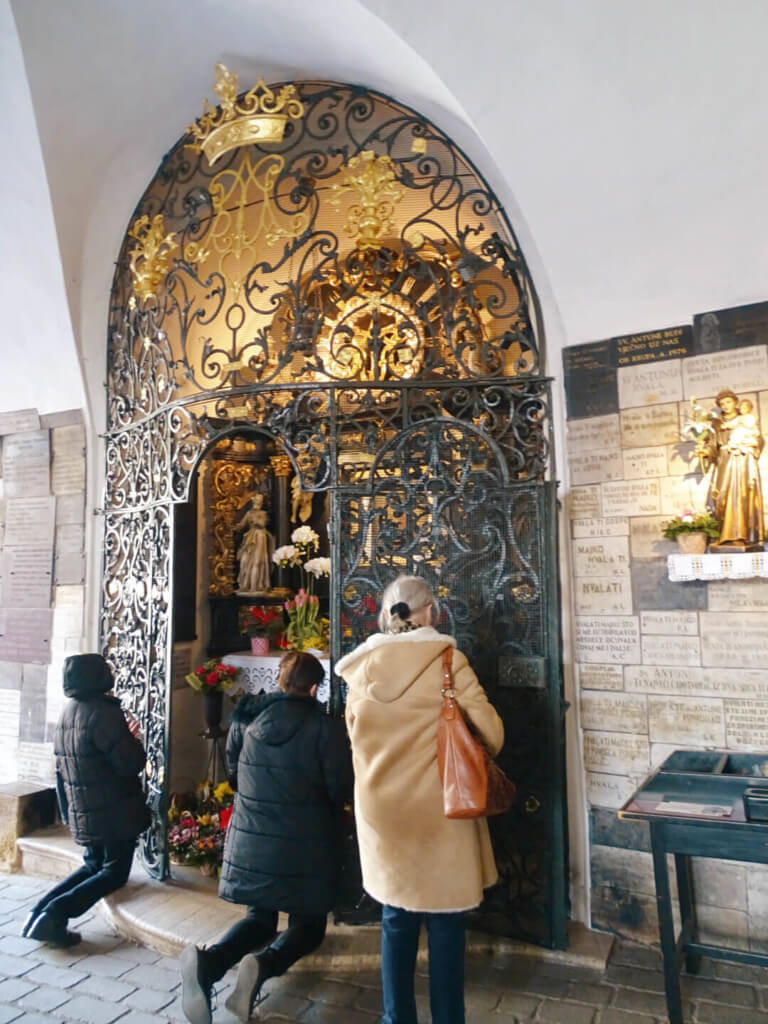 Praying at stone gate